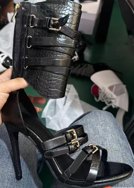 Sandal Strappy Heeled - รองเท้าส้นสูงแบบเปิดนิ้วเท้าหนังสีดำเซ็กซี่ สายรัดข้อเท้าแบบไขว้ ประดับหัวเข็มขัด ดีไซน์โปร่ง แฟชั่นสำหรับงานปาร์ตี้และงานแสดงบนเวที